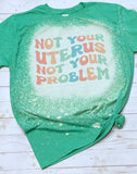 Not your uterus not your problem tee shirt shown on bleached heather purple